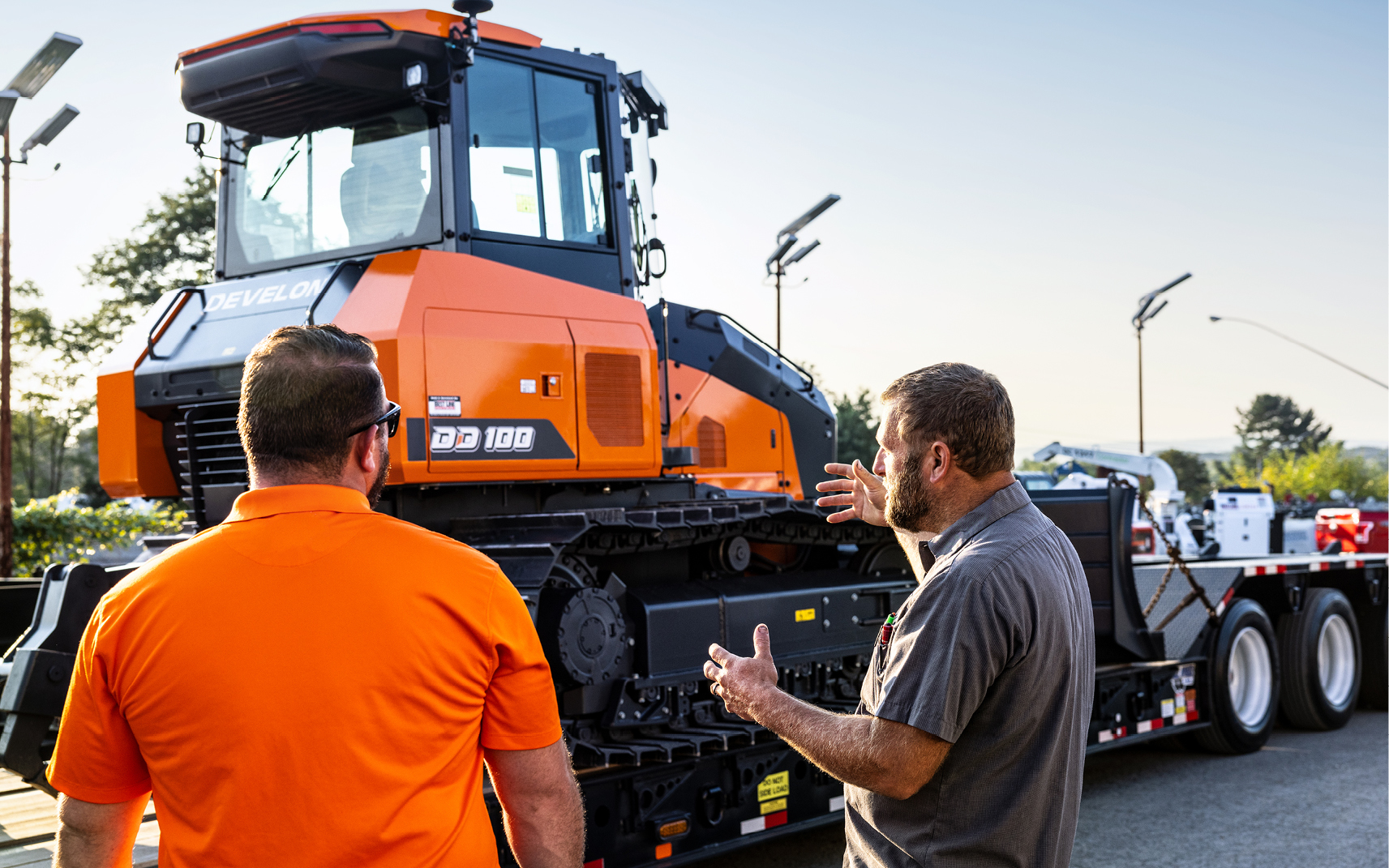 A dealer talks with a customer about a DEVELON DD100 dozer.