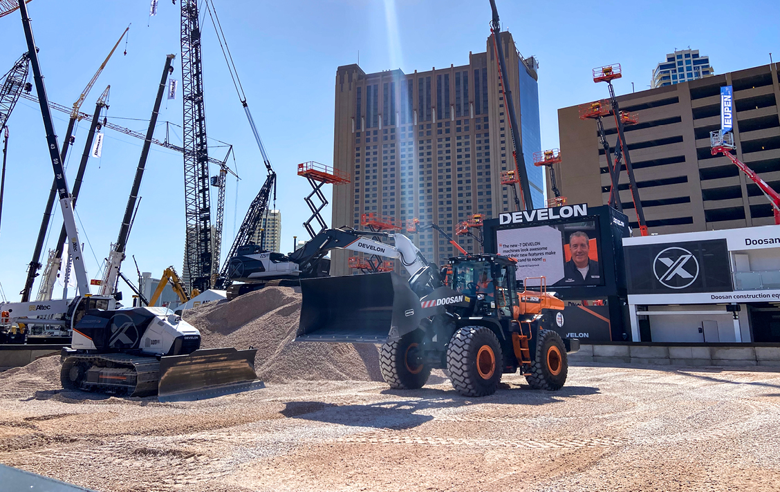 Photo looking into the demo area of the DEVELON CONEXPO booth during a demo of Concept-X2 autonomous equipment.