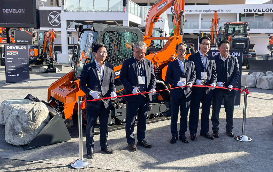 Photo of DEVELON leadership team at the ribbon cutting to introduce the new compact track loader and open the booth for CONEXPO 2023.