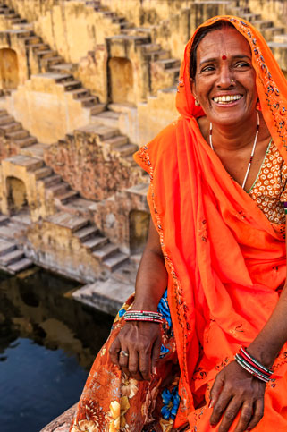 Indian woman resting inside stepwell in village near Jaipur, Rajasthan, India.