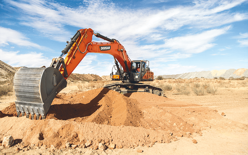 Dramatic photo of a Doosan -7 Series crawler excavator moving material on a job site.
