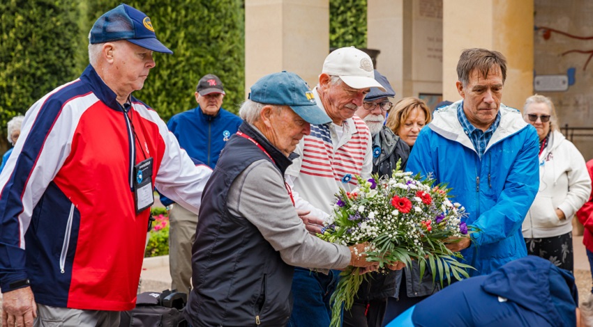 A group lays flowers during a special ceremony at the Normandy American Cemetery