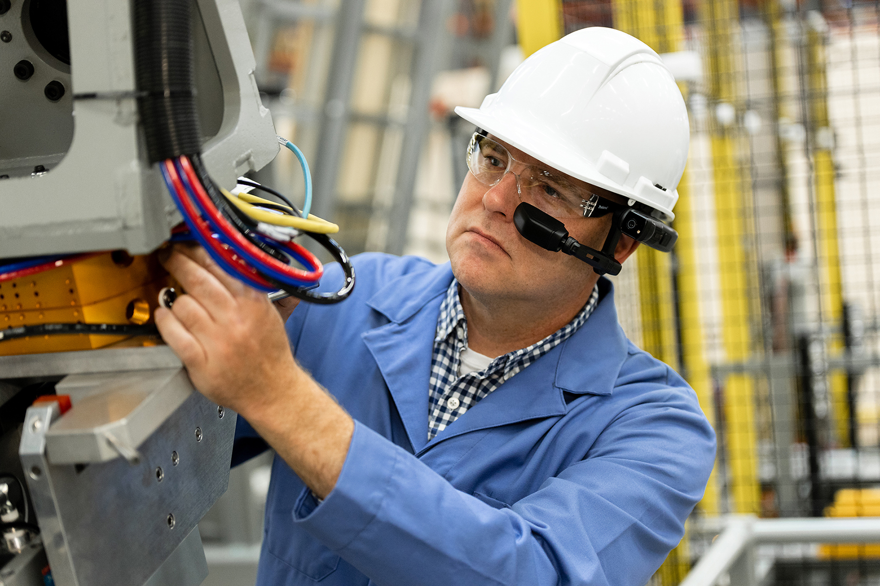 male worker in a warehouse with hard hat wearing Realwear technology