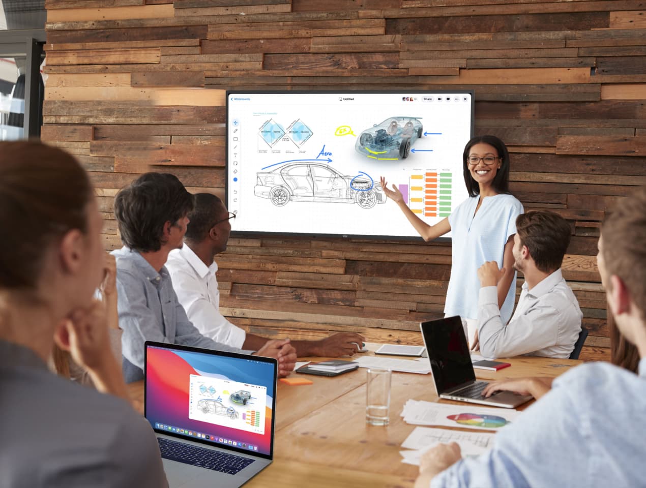 Office workers focused on whiteboard in conference room